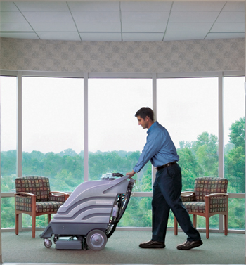 A Man cleaning the carpet of the office