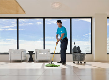 Man mopping the floor of an office