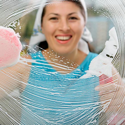 Women cleaning window with smiling face